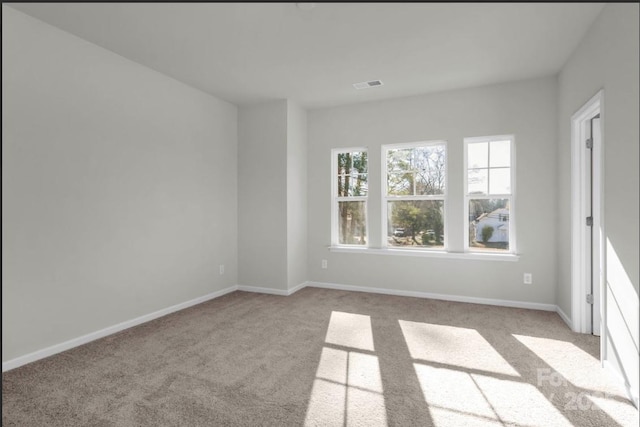 unfurnished room with carpet and baseboards