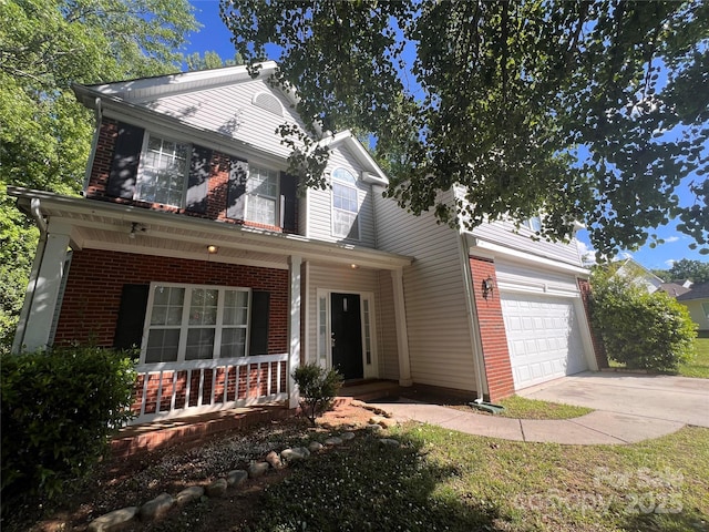 traditional home featuring covered porch, brick siding, concrete driveway, and a garage