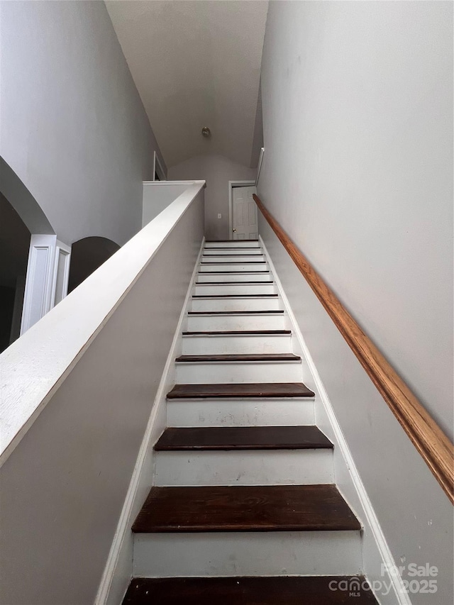 stairs featuring vaulted ceiling