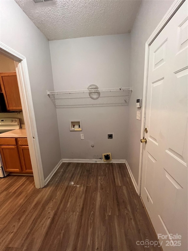 clothes washing area with hookup for an electric dryer, dark wood-type flooring, gas dryer hookup, washer hookup, and a textured ceiling
