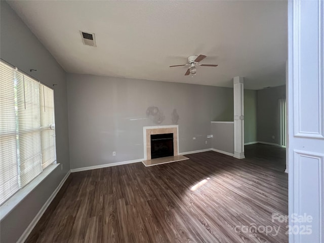 unfurnished living room featuring a ceiling fan, dark wood-style flooring, a fireplace, and baseboards