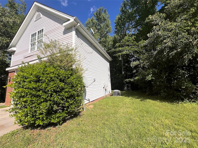 view of home's exterior with cooling unit and a yard