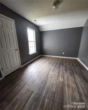 bonus room featuring baseboards, wood finished floors, and lofted ceiling