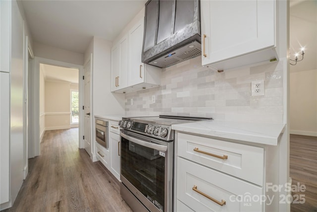 26056 Neptunes Lndg, Fort Mill, SC 29708 - kitchen with electric range, custom range hood, wood finished floors, white cabinetry, and decorative backsplash
