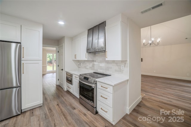 26056 Neptunes Lndg, Fort Mill, SC 29708 - kitchen featuring appliances with stainless steel finishes, baseboards, light wood-style flooring, a chandelier, and tasteful backsplash