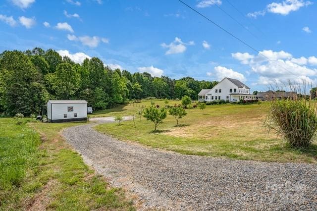 view of dirt / gravel road with a forest view