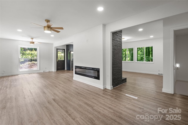 unfurnished living room with recessed lighting, wood finished floors, a ceiling fan, and baseboards