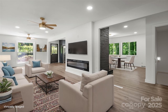 living area with light wood-style flooring, ceiling fan, recessed lighting, and baseboards
