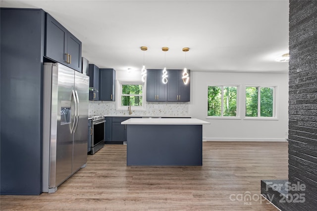 kitchen with stainless steel appliances, light wood-style floors, a sink, and light countertops
