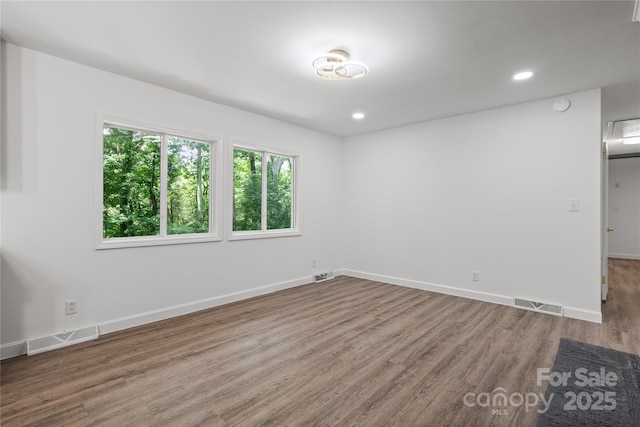 spare room featuring wood finished floors, baseboards, recessed lighting, and a smoke detector