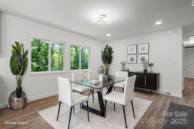 dining space featuring wood finished floors, baseboards, and recessed lighting