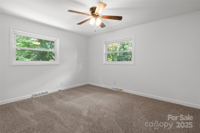 carpeted empty room with a ceiling fan and baseboards