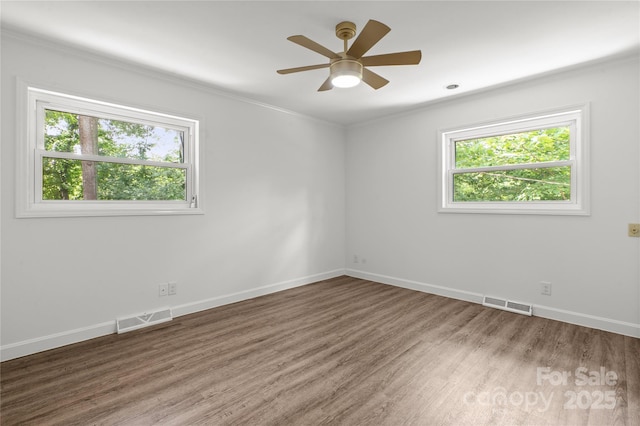 unfurnished room featuring wood finished floors, crown molding, baseboards, and ceiling fan