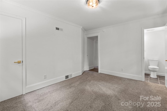 unfurnished bedroom with crown molding, carpet flooring, connected bathroom, and baseboards