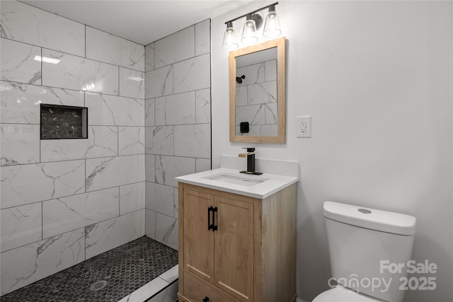 full bath featuring a tile shower, toilet, and vanity