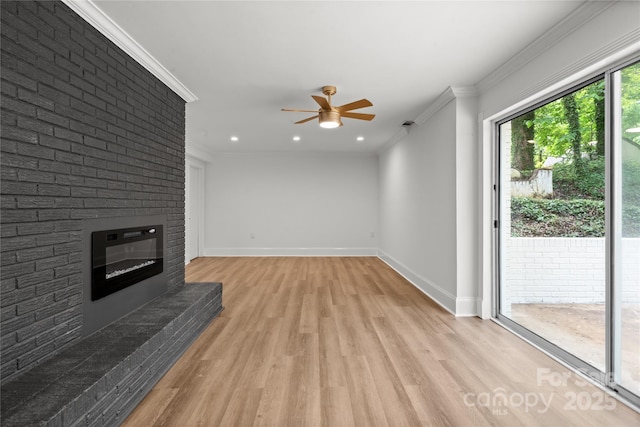 unfurnished living room with a ceiling fan, light wood-style floors, baseboards, crown molding, and a brick fireplace