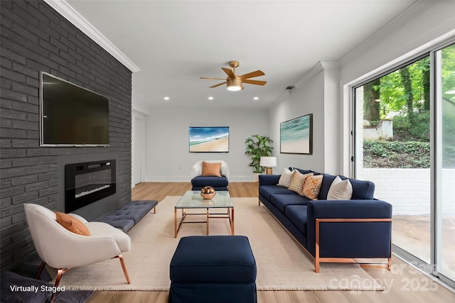 living area featuring crown molding, ceiling fan, wood finished floors, a brick fireplace, and recessed lighting