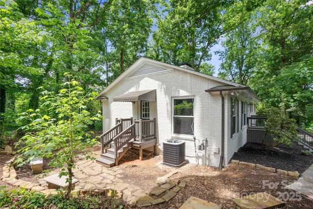 view of front of property featuring central AC and brick siding