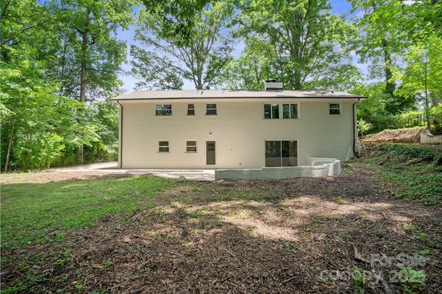 back of property with a patio area and a chimney