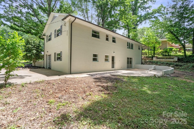 back of house with a patio area and brick siding