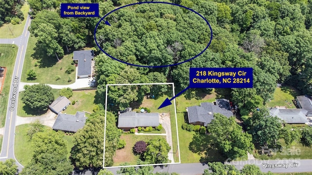 aerial overview of property's location with property boundaries highlighted and a heavily wooded area