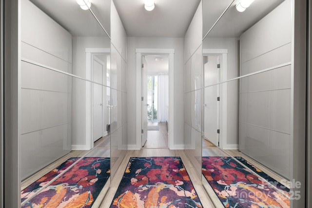 hall featuring light wood-style floors and baseboards