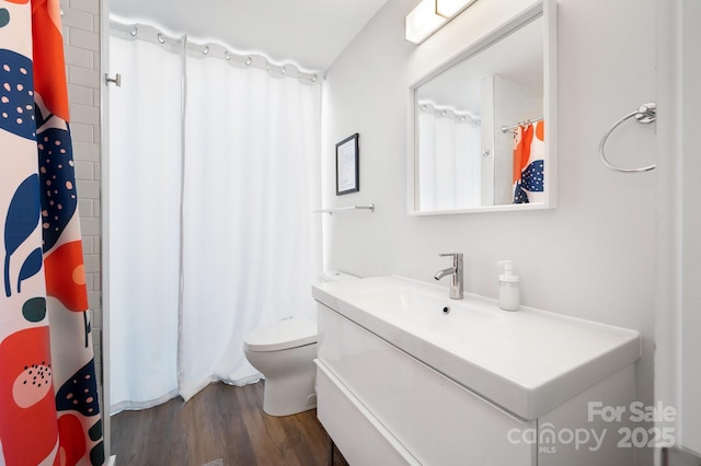 bathroom featuring toilet, wood finished floors, vanity, and a shower with shower curtain