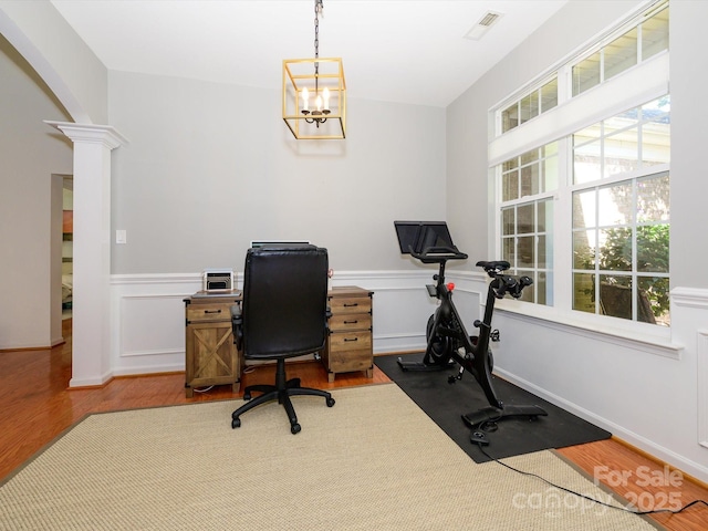 14336 Northridge Dr, Charlotte, NC 28269 - office space featuring ornate columns, arched walkways, wood finished floors, a wainscoted wall, and a chandelier