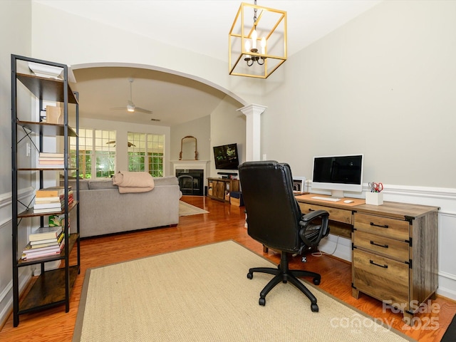 14336 Northridge Dr, Charlotte, NC 28269 - office space featuring a fireplace, arched walkways, wood finished floors, decorative columns, and a ceiling fan