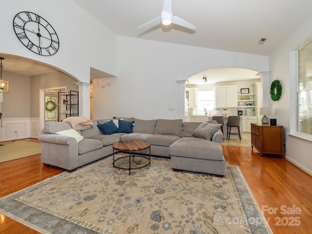 14336 Northridge Dr, Charlotte, NC 28269 - living room with ornate columns, healthy amount of natural light, light wood-style flooring, wainscoting, and a towering ceiling