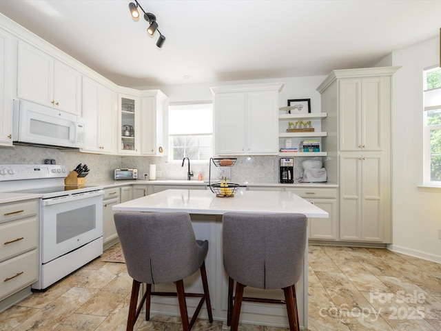 14336 Northridge Dr, Charlotte, NC 28269 - kitchen featuring white appliances, a kitchen breakfast bar, decorative backsplash, and light countertops