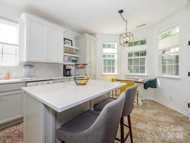 14336 Northridge Dr, Charlotte, NC 28269 - kitchen featuring a breakfast bar, light countertops, open shelves, and tasteful backsplash