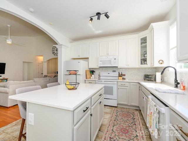 14336 Northridge Dr, Charlotte, NC 28269 - kitchen with white appliances, a sink, arched walkways, open floor plan, and backsplash