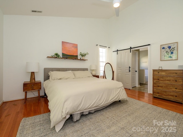 14336 Northridge Dr, Charlotte, NC 28269 - bedroom with wood finished floors, a barn door, baseboards, and ceiling fan