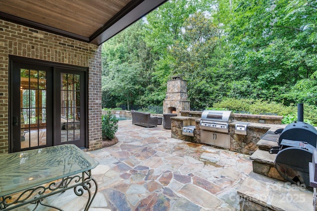 8534 Highgrove St, Charlotte, NC 28277 - view of patio / terrace featuring an outdoor stone fireplace, french doors, area for grilling, and exterior kitchen