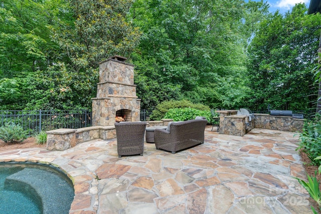 8534 Highgrove St, Charlotte, NC 28277 - view of patio / terrace featuring an outdoor stone fireplace, an outdoor kitchen, fence, and area for grilling