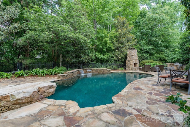 8534 Highgrove St, Charlotte, NC 28277 - view of swimming pool featuring a patio, an outdoor stone fireplace, and a fenced backyard