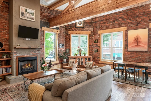 14 N Main St Unit 1 & 2, Waynesville, NC 28786 - living room with high vaulted ceiling, wood-type flooring, a warm lit fireplace, beam ceiling, and brick wall