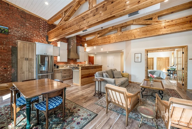 14 N Main St Unit 1 & 2, Waynesville, NC 28786 - living room featuring high vaulted ceiling, brick wall, light wood finished floors, beamed ceiling, and baseboards