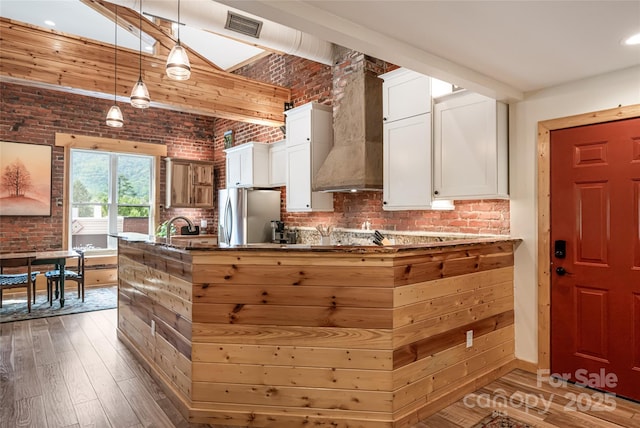 14 N Main St Unit 1 & 2, Waynesville, NC 28786 - kitchen featuring freestanding refrigerator, hardwood / wood-style floors, white cabinets, brick wall, and custom range hood