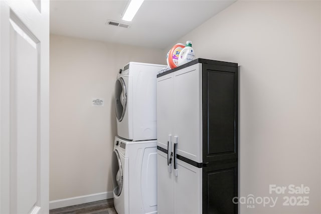 14 N Main St Unit 1 & 2, Waynesville, NC 28786 - washroom featuring stacked washing machine and dryer, cabinet space, wood finished floors, and baseboards