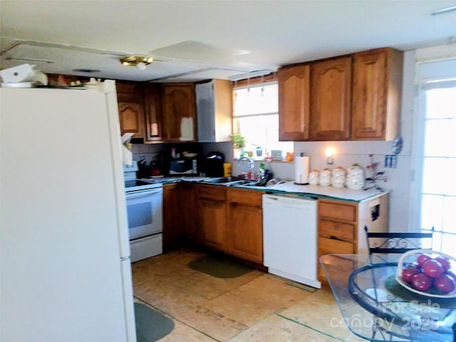 34 Edney Ln, Arden, NC 28704 - kitchen with white appliances, brown cabinetry, light countertops, light tile patterned floors, and a sink