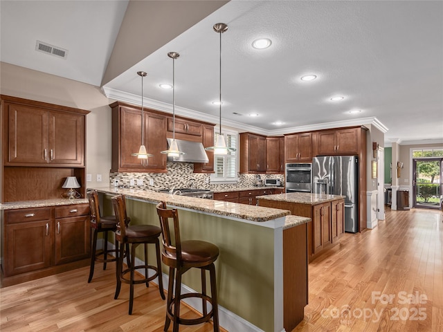 5 Holland Mountain Vw, Asheville, NC 28804 - kitchen with stainless steel appliances, decorative backsplash, light wood-style flooring, light stone counters, and a kitchen bar