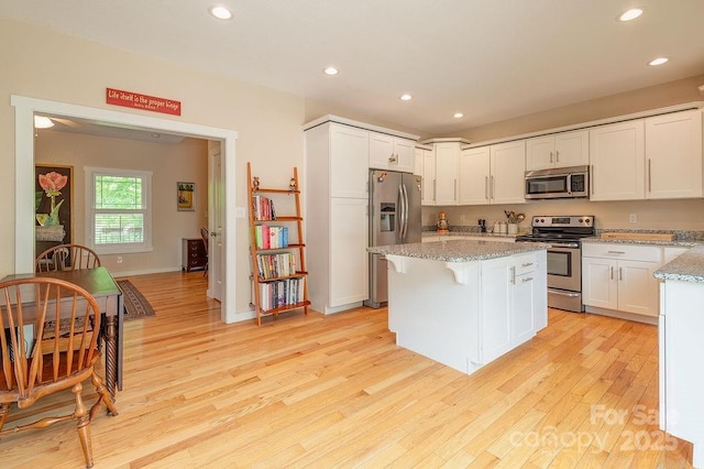 104 Bobby Ridge Dr, Leicester, NC 28748 - kitchen featuring appliances with stainless steel finishes, recessed lighting, light wood finished floors, a center island, and light stone countertops