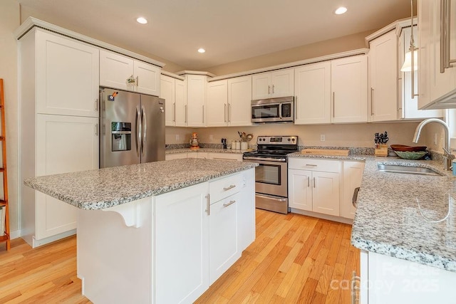 104 Bobby Ridge Dr, Leicester, NC 28748 - kitchen with stainless steel appliances, a sink, light wood-style flooring, a center island, and recessed lighting