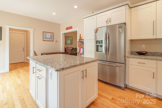 104 Bobby Ridge Dr, Leicester, NC 28748 - kitchen with stainless steel fridge with ice dispenser, a center island, light wood-type flooring, recessed lighting, and light stone countertops