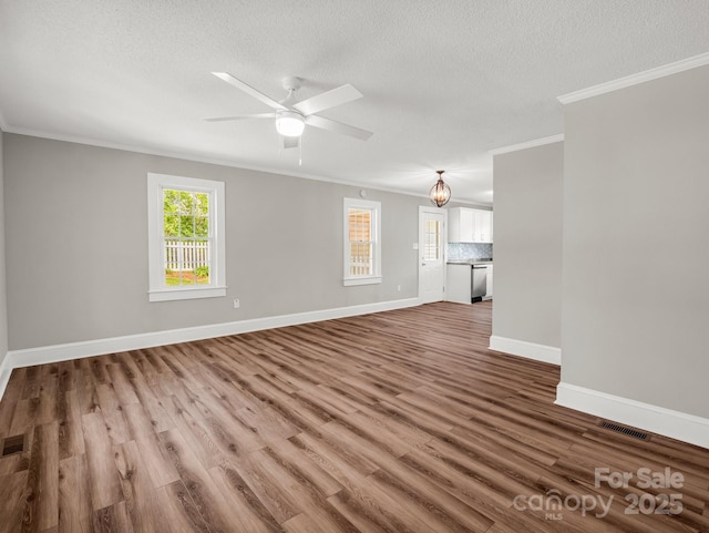 411 W Sycamore St, Lincolnton, NC 28092 - unfurnished living room with ornamental molding, wood finished floors, a textured ceiling, baseboards, and a ceiling fan