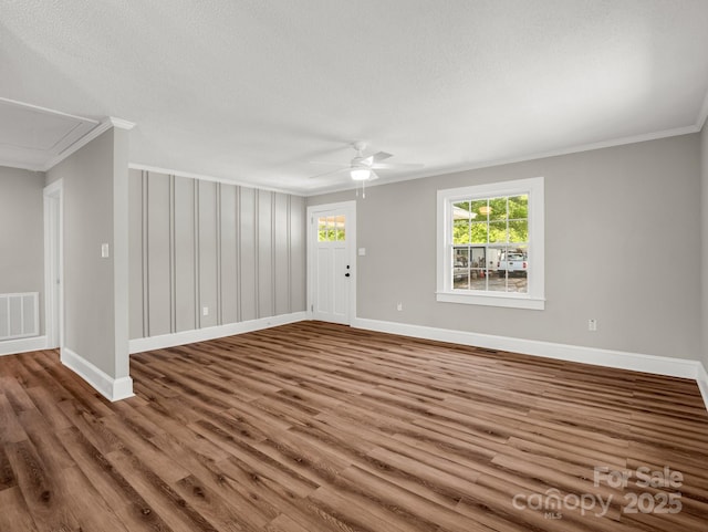 411 W Sycamore St, Lincolnton, NC 28092 - unfurnished living room featuring attic access, crown molding, ceiling fan, wood finished floors, and baseboards
