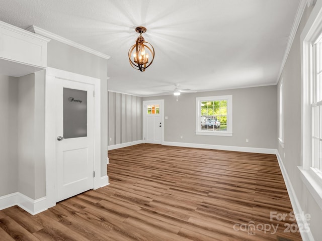411 W Sycamore St, Lincolnton, NC 28092 - unfurnished living room with crown molding, wood finished floors, a chandelier, ceiling fan, and baseboards
