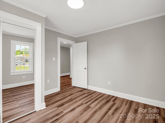 411 W Sycamore St, Lincolnton, NC 28092 - unfurnished bedroom with wood finished floors, baseboards, and crown molding